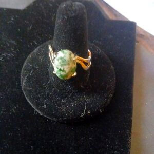 Green and white stone inside of silver ring